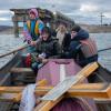 Eine Frau sitzt in einem Boot, das den Fluss Siverskyj-Donez überquert, um den Sarg ihres toten Sohnes zu transportieren, der bei Kämpfen mit den Russen gefallen ist.