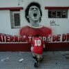Ein Fan mit einem Trikot der Argentinos Juniors kniet vor einem Wandgemälde mit der Abbildung von Diego Mardona in Buenos Aires. Die argentinische Fußball-Legende ist im Alter von nur 60 Jahren gestorben.
