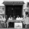 Menschen in Lomé (Togo) vor dem deutschen Goethe-Institut. Auf dem Tisch steht eine kleine Goethe-Skulptur. Das Institut in Lomé wurde 1961 gegründet, das Bild entstand in den frühen 1970er Jahren.  	
