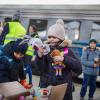Ukrainische Kinder erhalten Stofftiere auf einem polnischen Bahnhof.