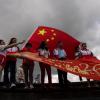 Peking-Befürworter halten chinesische Fahnen anlässlich des 26. Jahrestages der Übergabe der Kontrolle über Hongkong von Großbritannien an China. Führende EU-Vertreter erheben mit einem neuen Bericht zu den Entwicklungen in Hongkong schwere Vorwürfe gegen die politische Führung in Peking.