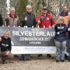 Schon Wochen vor dem Lauf ist die Stimmung gut. Lauforganisator Leo Klocke (rechts) freut sich zusammen mit den Beteiligten von der BEW, der Wasserwacht, dem Verschönerungsverein, der Stadt Schwabmünchen und den Ulrichswerkstätten auf den Start am Silvestertag. 	