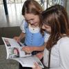 Die neunjährige Alina (links) und die zehn Jahre alte Katharina halten ihr neues Schulbuch in den Händen. 