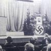 Bei der Trauerfeier des Alpenvereins für den 1939 verstorbenen Augsburger Zweigführer Carl Wolfrum prangt an der Tribüne ein Hakenkreuz anstatt ein Edelweiß. 	