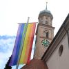 Die Regenbogenfahne – hier vor einer katholischen Kirche in Augsburg – steht unter anderem für Toleranz und symbolisiert die Vielfalt sexueller Orientierungen und geschlechtlicher Identitäten.  