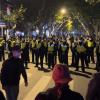 Chinesische Polizisten versperren den Zugang zu einem Platz, an dem sich Demonstranten versammelt hatten. In China hat die strenge Corona-Politik am Wochenende zu den größten Protesten seit Jahrzehnten geführt. 

