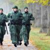 Fünf Polizisten laufen am Freitag (28.10.2011) in Augsburg (Schwaben) auf einem Waldweg. In der Nacht war bei einer Schießerei Polizist Mathias Vieth getötet und eine Kollegin verletzt worden. Archivbild