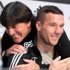 Bundestrainer Joachim Löw (l) umarmt Lukas Podolski bei der Pressekonferenz der Nationalmannschaft in Dortmund.