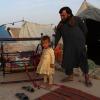 Ein Mann und kleine Kinder stehen in einem behelfsmäßigen Lager in der Provinz Balkh, Afghanistan. Seit Beginn des Abzugs der internationalen Truppen aus Afghanistan ist die Zahl der Binnenflüchtlinge deutlich gestiegen. 