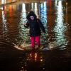 Eine Frau watet durch das Hochwasser am Stadthafen von Wismar.