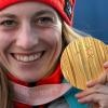 Monoskifahrerin Anna Schaffelhuber strahlt mit ihrer Goldmedaille in der Hand.