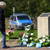 Eine Frau legt am Gedenkstein für die NSU-Opfer auf dem Halitplatz in Kassel Blumen ab.