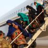 Mitglieder des US-Militärs helfen afghanischen Frauen auf dem Militärflughafen Sigonella in Italien aus dem Flugzeug. 	
