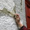 Ein Latex-Wasser-Gemisch wird auf die Wände in St. Johann Baptist aufgetragen. Ist die Masse getrocknet, kann man sie abziehen – und mit ihr den Schmutz vieler vergangener Jahre. 	