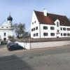 Der Neubau des Rehlinger Pfarrhauses hat genau die gleichen Abmessungen wie das vor 40 Jahren abgebrannte alte Pfarrhaus. Heute ist alles ordentlich angelegt, auch die Mauer und der Zaun. Im Hintergrund ist die Rehlinger Pfarrkirche St. Vitus und St. Katharina zu sehen.