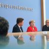 Bundeskanzlerin Angela Merkel (Mitte) spricht in der Bundespressekonferenz neben Corinna Buschow, Mitglied im Vorstand der Bundespressekonferenz, und Regierungssprecher Steffen Seibert.  