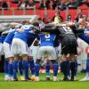 Die Spieler des FC Schalke 04 stehen vor Spielbeginn gemeinsam auf dem Platz im Kreis.