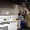 Nach dem Brand hat Bewohner Abdu Karim aus Somalia schon mit der Reinigung der ausgeräumten Küche begonnen.