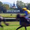 Jockeys reiten auf der Galopprennbahn Iffezheim.