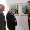 Siegfried Geißler, Günter Krell und Landrat Peter von der Grün bestaunen die Fotografien, die im Auenzentrum ausgestellt sind. 	