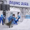 Im Nationalen Biathlonzentrum fegen Olympia-Mitarbeiter Schnee. 