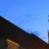 Ihre Nachtruhe verbringen die Störche am liebsten auf hohen Gebäuden, wie hier auf dem Kirchenschiff von Sankt Georg in Nördlingen. 	