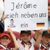 Diese jungen Fußballfans zeigen vor Spielbeginn in Augsburg ein Plakat mit der Aufschrift "Jerome zieh neben uns ein".