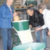 Auf dem Hof der Kretschmers: Gäste eines Sauerkrautkurses üben sich an der über 60 Jahre alten Krauthobelmaschine.  