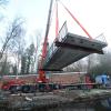 Hier schwebt die neue Granitbrücke noch: Etwa 26 Tonnen hängen hier am Kran. Gestern wurde der Steg beim westlichen Eingang des Glacis-Parks eingesetzt. 