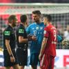 Sven Ulreich und Robert Lewandowski  diskutieren mit Schiedsrichter Felix Zwayer.