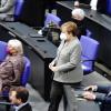 Bundeskanzlerin Angela Merkel (CDU) geht während der Debatte zur Änderung des Infektionsschutzgesetzes durch den Plenarsaal.
