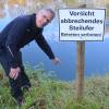 Flussmeister Gerhard Bronnenmayer zeigt eine besonders gefährliche Stelle, wo unterhalb der Pflanzen das Ufer bereits unterhöhlt ist. 