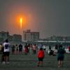 Menschen beobachten am Cocoa Beach im US-Bundesstaat Florida, wie die SpaceX-Rakete in Cape Canaveral abhebt.