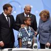 Kanzlerin Merkel und Präsident Macron (links) in Bonn mit einem jungen Klimaschützer aus Fidschi und Konferenzleiter Bainimarama. 	 	