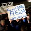 Die Teilnehmer einer "Pegida"-Demonstration in Dresden halten Transparente in die Höhe.