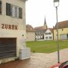 Dort, wo jetzt der Rasen wächst, hätte einmal ein Teil des Aindlinger Marktzentrums entstehen sollen. Das alte Haus der „Verkaufsstätte Zurek“ steht noch, das Haus Gabelsberger wurde abgerissen. 