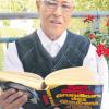 Schmid liest viel Theologisches im Ruhestand. Auf einem Balkon im Sozialzentrum St. Martin nahm der Geistliche das Buch „Grundkurs des Glaubens“ zur Hand.    