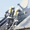Die Feuerwehrleute mussten die Dachplatten entfernen, um die Glutnester finden und ablöschen zu können. Insgesamt waren etwa 100 Einsatzkräfte vor Ort, um den Brand zu bekämpfen.  