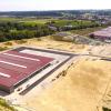 Das Betriebsgelände der Firma Unsinn hat sich seit 2018 verdoppelt und umfasst mittlerweile 160.000 Quadratmeter. Vorne zu sehen ist die neue Halle D, die Schweißerei. Rechts oben die Hallen A bis C, die Verwaltung und Entwicklung samt Blick auf die Gemeinde Holzheim.  	