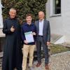 Jonas Ruppert, der im Gymnasium in St. Ottilien sein Abitur gemacht hat, freut sich zusammen mit Pater Theophil Gaus und Schulleiter Andreas Walch über seinen BUW-Hauptpreis.