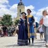 Viele Besucher und Besucherinnen vom Schloßfest sind prächtig gekleidet. 
