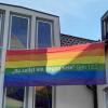 Pallottinerpater Christoph Lentz befestigt die Regenbogenfahne mit dem Spruch „Du sollst ein Segen sein“  am Pallotti-Haus in Friedberg. 