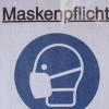 Ein Plakat mit der Aufschrift "Maskenpflicht": Eine Frau will sich daran nicht halten.