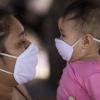 Mutter und Kind mit Mundschutz: Die Forscher fanden keinen Unterschied in der Viruslast zwischen verschiedenen Altersgruppen.
