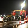 Feuerwehrleute stehen neben zwei Unfallwagen. Ein Autofahrer hat auf der A8 einen Unfall verursacht, in dessen Folge drei weitere Autos ebenfalls verunglückten. 