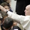 Papst Franziskus streichelt ein Baby, während er zum traditionellen Weihnachtsempfang in der Vatikanischen Audienzhalle eintrifft. Der Pontifex rief die Gläubigen weltweit zu mehr Toleranz auf. 	 	