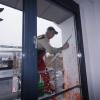 Hamsa Cinar reinigt nach dem Farbanschlag die Fenster am Präsidiumsgebäude der Universität Augsburg.