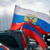 Flaggen mit den russischen Nationalfarben und dem russischen Staatswappen wehen an einem Auto: Am Sonntag und Montag könnte es in Berlin erneut zu pro-russischen .Aktionen kommen.