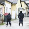 Razzia gegen den politischen Islam.: Zwei uniformierte Polizisten stehen in einer Einfahrt an einem Einsatzort der Operation "Luxor" in Graz.