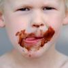Ein kleiner Junge hat genascht: Speziell für Kinder angepriesene Lebensmittel sind nach einer Studie meist ungesunde Kalorienbomben. Foto: Julian Stratenschulte/ Symbol dpa